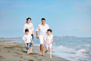 contento giovane famiglia avere divertimento su spiaggia foto