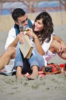 giovane coppia godendo picnic su il spiaggia foto