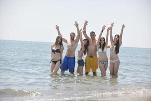 contento persone gruppo avere divertimento e in esecuzione su spiaggia foto