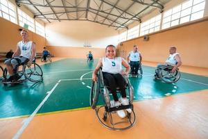 un' ritratto di un' donna con un' invalidità seduta nel un' sedia a rotelle in attesa per un' pallacanestro gioco per inizio. selettivo messa a fuoco foto