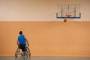 un' foto di un' guerra veterano giocando pallacanestro con un' squadra nel un' moderno gli sport arena. il concetto di sport per persone con disabilità