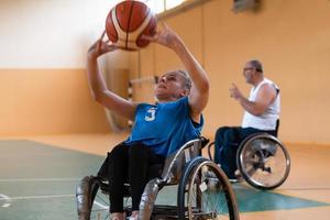 un' giovane donna giocando sedia a rotelle pallacanestro nel un' professionale squadra. Genere uguaglianza, il concetto di gli sport con disabilità. foto