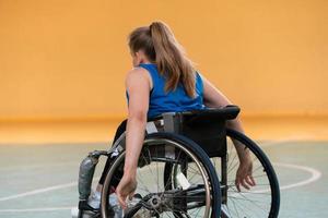un' giovane donna giocando sedia a rotelle pallacanestro nel un' professionale squadra. Genere uguaglianza, il concetto di gli sport con disabilità. foto