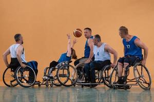 Disabilitato guerra veterani misto gara opporsi pallacanestro squadre nel sedie a rotelle fotografato nel azione mentre giocando un importante incontro nel un' moderno sala. foto