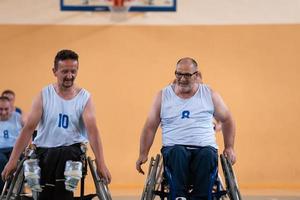 un' squadra di guerra veterani nel sedie a rotelle giocando pallacanestro, festeggiare punti ha vinto nel un' gioco. alto cinque concetto foto