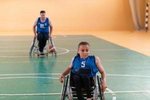 un' giovane donna giocando sedia a rotelle pallacanestro nel un' professionale squadra. Genere uguaglianza, il concetto di gli sport con disabilità. foto