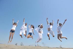 contento persone gruppo avere divertimento e in esecuzione su spiaggia foto