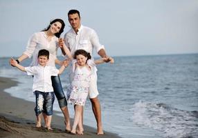 contento giovane famiglia avere divertimento su spiaggia foto