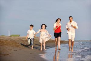 contento giovane famiglia avere divertimento su spiaggia foto