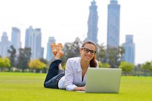 donna con il computer portatile nel parco foto