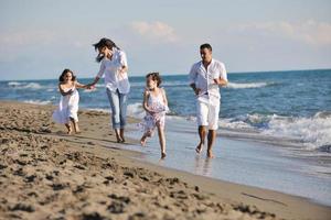 contento giovane famiglia avere divertimento su spiaggia foto