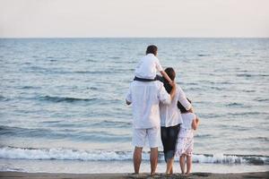 contento giovane famiglia avere divertimento su spiaggia foto