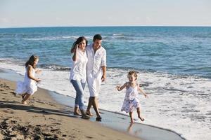 contento giovane famiglia avere divertimento su spiaggia foto