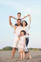 contento giovane famiglia avere divertimento su spiaggia foto