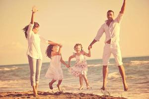 contento giovane famiglia avere divertimento su spiaggia foto