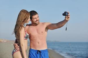 contento giovane coppia nel amore assunzione fotografie su spiaggia