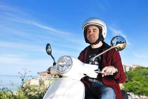 giovane uomo cavalcata retrò scooter foto