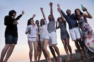 gruppo di giovane persone godere estate festa a il spiaggia foto