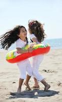 gruppo di bambini felici che giocano sulla spiaggia foto