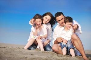 contento giovane famiglia avere divertimento su spiaggia foto