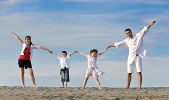 contento giovane famiglia avere divertimento su spiaggia foto