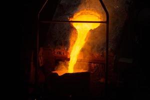 un' processi di mestolo Riempimento con fuso caldo acciaio a partire dal forno con Fumo - avvicinamento con selettivo messa a fuoco foto