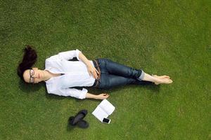 giovane donna che legge un libro nel parco foto