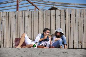 giovane coppia godendo picnic su il spiaggia foto