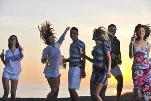 gruppo di giovane persone godere estate festa a il spiaggia foto