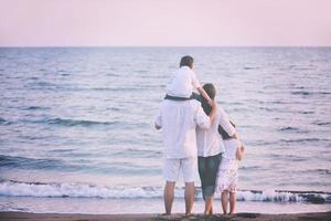 contento giovane famiglia avere divertimento su spiaggia foto