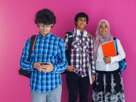 un' gruppo di arabo adolescenti, un' alunno squadra a piedi inoltrare in il futuro e indietro per scuola il concetto di un' rosa sfondo. il concetto di riuscito formazione scolastica per giovane le persone. selettivo messa a fuoco foto