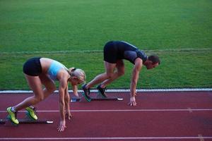 donna gruppo in esecuzione su Atletica gara traccia a partire dal inizio foto