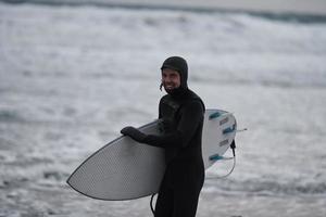 artico surfer andando di spiaggia dopo fare surf foto