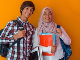 un' gruppo di arabo adolescenti, un' alunno squadra a piedi inoltrare in il futuro e indietro per scuola il concetto di un' giallo sfondo. il concetto di riuscito formazione scolastica per giovane le persone. selettivo messa a fuoco foto