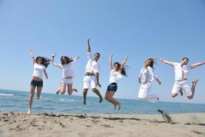 contento persone gruppo avere divertimento e in esecuzione su spiaggia foto