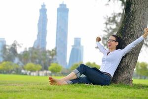 bellissimo giovane donna con tavoletta nel parco foto