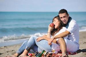 giovane coppia godendo picnic su il spiaggia foto