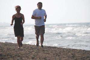 coppia in esecuzione su spiaggia foto