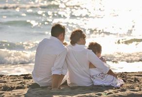 contento giovane famiglia avere divertimento su spiaggia foto