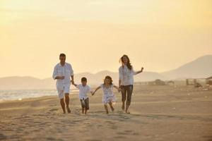 contento giovane famiglia avere divertimento su spiaggia foto