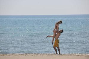 la giovane coppia felice si diverte sulla spiaggia foto