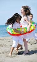 gruppo di bambini felici che giocano sulla spiaggia foto