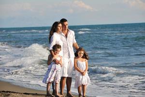 contento giovane famiglia avere divertimento su spiaggia foto