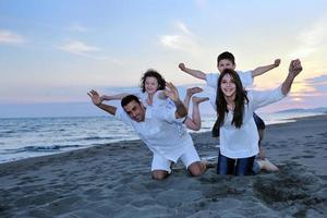 contento giovane famiglia avere divertimento su spiaggia foto