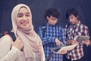 arabo adolescenti gruppo Lavorando su il computer portatile e tavoletta computer foto