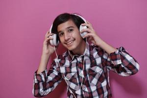 arabo adolescenziale ragazzo indossare cuffie e ascoltando per musica foto