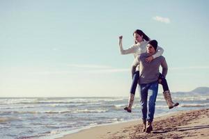 coppia avendo divertimento a spiaggia durante autunno foto