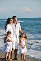 contento giovane famiglia avere divertimento su spiaggia foto