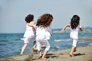 gruppo di bambini felici che giocano sulla spiaggia foto