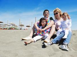 contento giovane famiglia avere divertimento su spiaggia foto